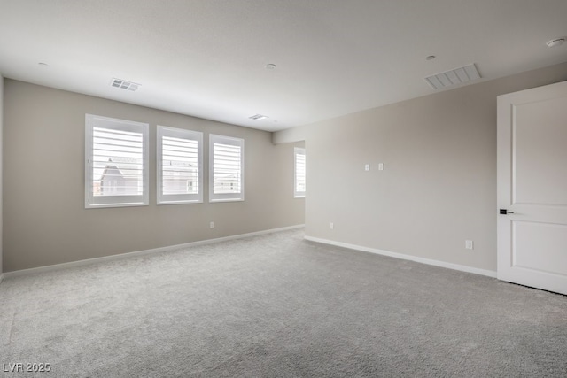spare room with carpet, baseboards, and visible vents