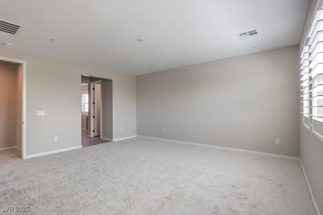 carpeted spare room featuring visible vents and baseboards