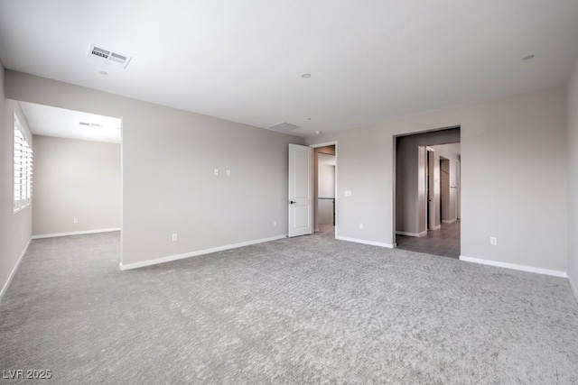 carpeted empty room featuring baseboards and visible vents