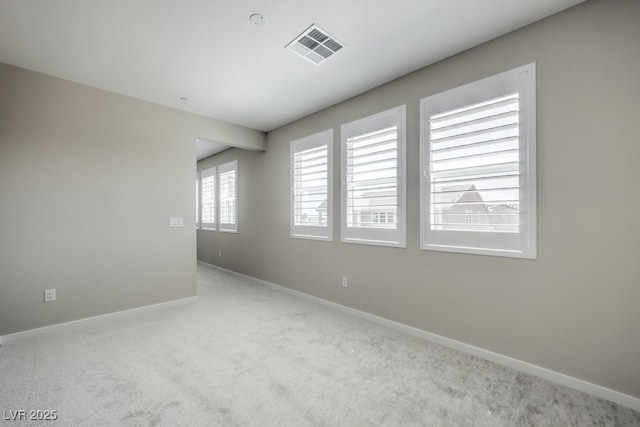 carpeted empty room featuring baseboards and visible vents