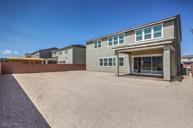 rear view of property with central air condition unit, stucco siding, a patio area, and a fenced backyard