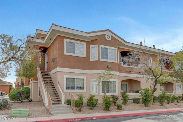 view of front of house featuring stucco siding and stairs