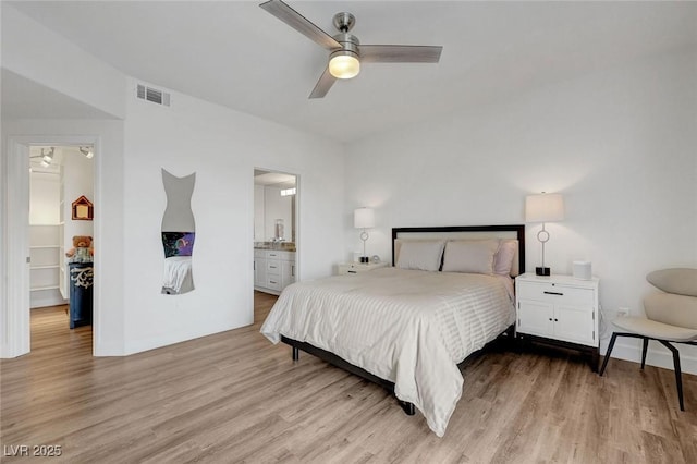 bedroom with ensuite bath, visible vents, light wood-type flooring, and a ceiling fan