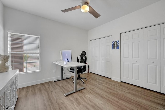 home office with baseboards, ceiling fan, and light wood-style flooring