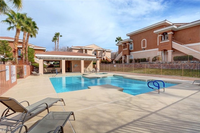 pool with a patio and fence