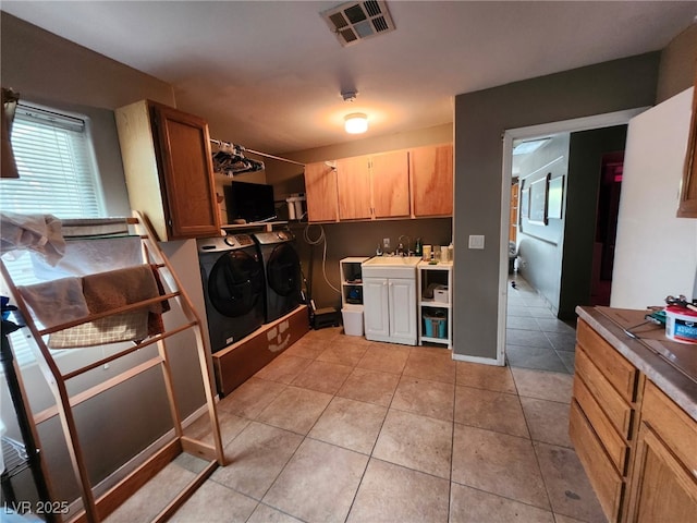 1812 Ivanhoe Way, Las Vegas, NV 89102 - washroom featuring independent washer and dryer, cabinet space, and light tile patterned flooring