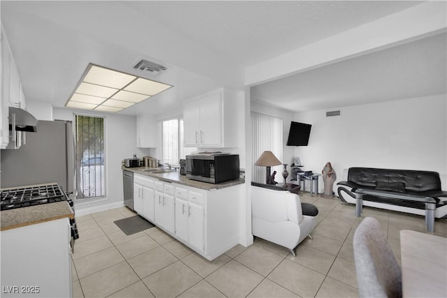 1440 Vegas Valley Dr Unit 1, Las Vegas, NV 89169 - kitchen with appliances with stainless steel finishes, a sink, white cabinets, light countertops, and light tile patterned floors