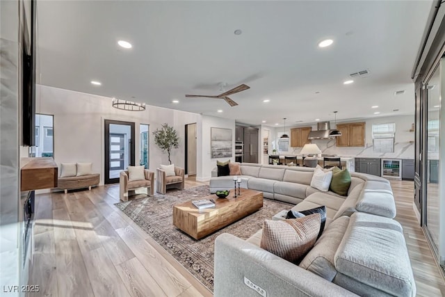 living room with recessed lighting, beverage cooler, visible vents, and light wood-style flooring
