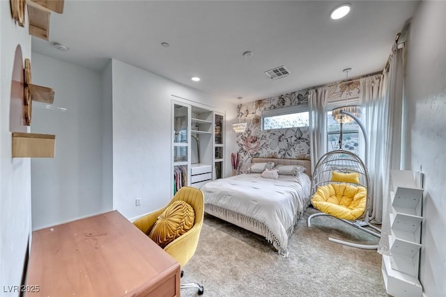 bedroom with a closet, a walk in closet, carpet, visible vents, and recessed lighting