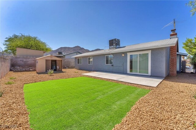 6770 Laronda Ln, Las Vegas, NV 89156 - back of property featuring a storage unit, a fenced backyard, a patio area, and stucco siding