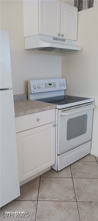 1832 Lewis Ave, Las Vegas, NV 89101 - kitchen with light tile patterned flooring, white cabinets, under cabinet range hood, and white appliances