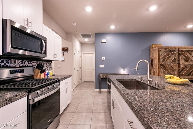 10125 Sequoia Falls Pl, Las Vegas, NV 89149 - kitchen with stainless steel appliances, a sink, white cabinetry, light tile patterned floors, and recessed lighting