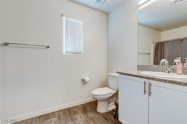 6804 Surf Green Ct, North Las Vegas, NV 89086 - bathroom with wood finished floors, toilet, baseboards, vanity, and a shower with curtain