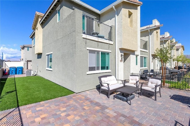 6804 Surf Green Ct, North Las Vegas, NV 89086 - rear view of property with a balcony, stucco siding, a patio area, an outdoor living space, and central AC