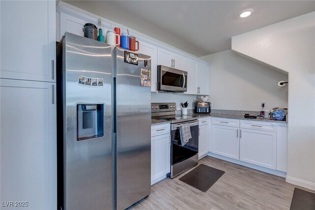 6804 Surf Green Ct, North Las Vegas, NV 89086 - kitchen with appliances with stainless steel finishes, white cabinetry, light wood-style flooring, stone countertops, and recessed lighting