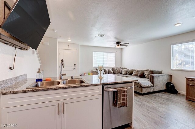 6804 Surf Green Ct, North Las Vegas, NV 89086 - kitchen with stainless steel dishwasher, a sink, white cabinets, ceiling fan, and light wood-style flooring
