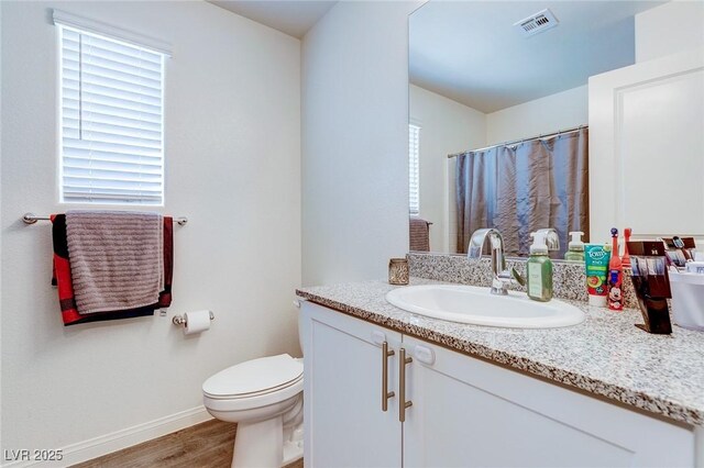 6804 Surf Green Ct, North Las Vegas, NV 89086 - full bath with wood finished floors, toilet, vanity, baseboards, and a shower with shower curtain