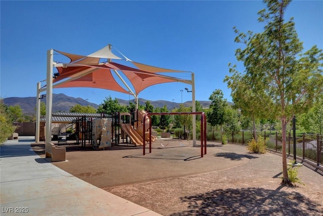 communal playground featuring fence and a mountain view
