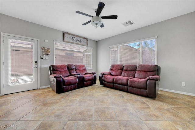 tiled living area with visible vents, baseboards, and ceiling fan