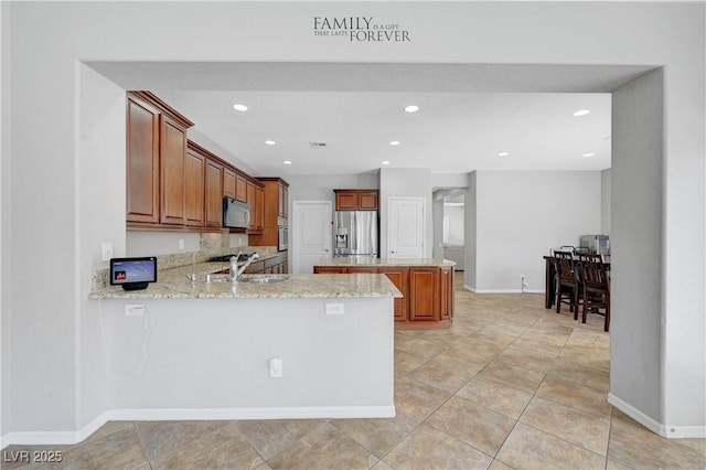 kitchen with light stone countertops, baseboards, recessed lighting, a sink, and stainless steel appliances