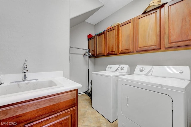 clothes washing area with a sink, cabinet space, light tile patterned floors, and washing machine and dryer