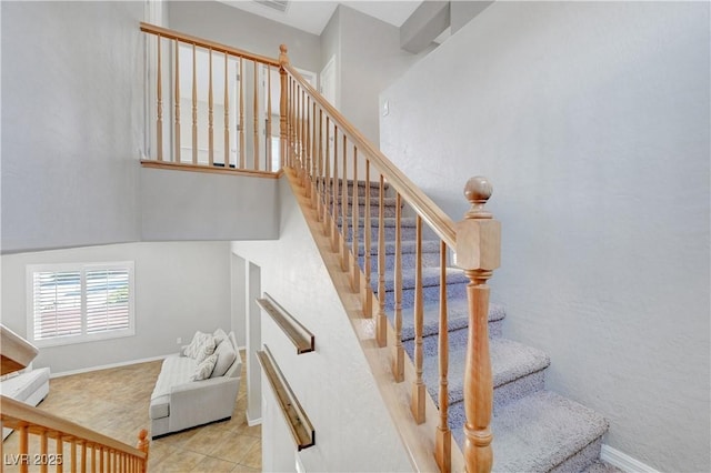 stairway featuring baseboards, tile patterned flooring, and visible vents