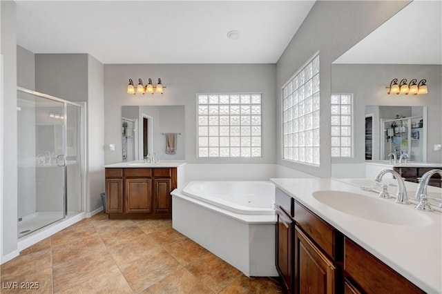 full bath with a garden tub, a sink, two vanities, and a shower stall