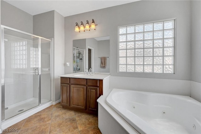 full bath featuring vanity, a tub with jets, a healthy amount of sunlight, and a stall shower