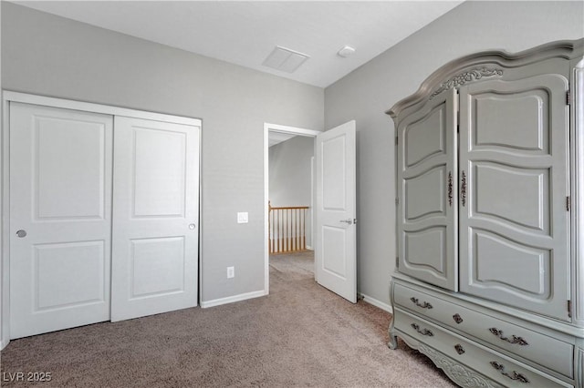 unfurnished bedroom featuring light colored carpet, baseboards, visible vents, and a closet