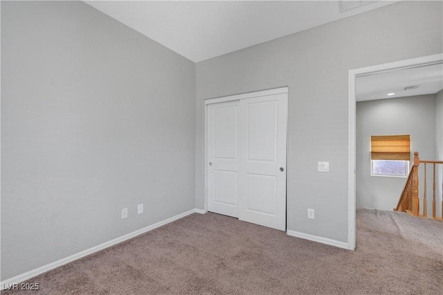 unfurnished bedroom featuring baseboards, carpet flooring, and a closet