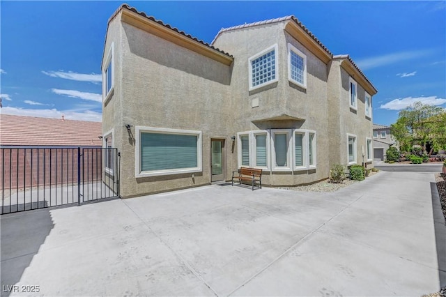 back of property featuring fence and stucco siding