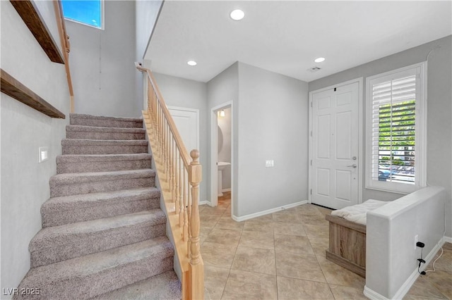 entryway with light tile patterned flooring, baseboards, recessed lighting, and stairway
