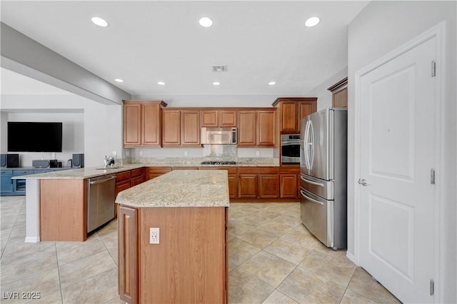 kitchen with a kitchen island, visible vents, light tile patterned floors, a peninsula, and stainless steel appliances