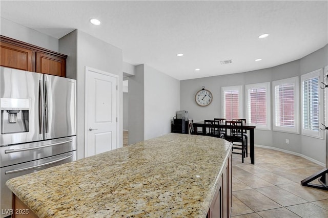 kitchen featuring a center island, recessed lighting, light tile patterned floors, stainless steel refrigerator with ice dispenser, and visible vents