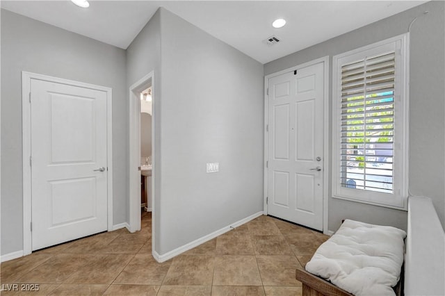 foyer with light tile patterned flooring, baseboards, and visible vents