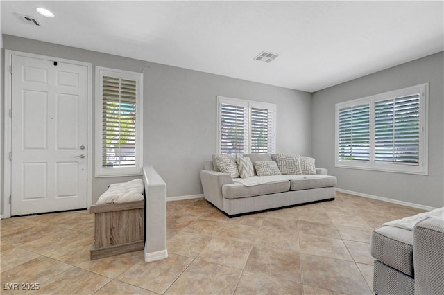 living room with light tile patterned flooring, visible vents, and a healthy amount of sunlight