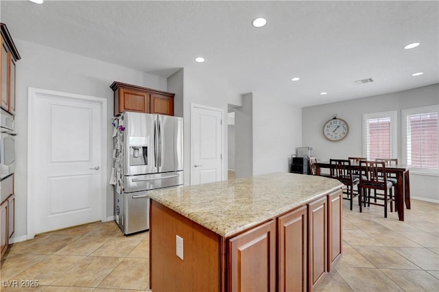 kitchen featuring a kitchen island, appliances with stainless steel finishes, light tile patterned floors, and visible vents