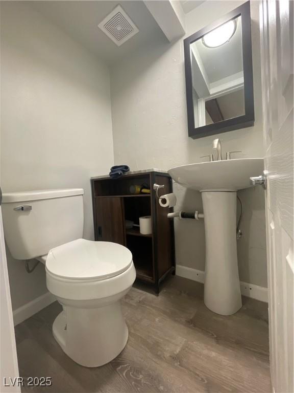 311 Fay Ave, Ely, NV 89301 - half bath with baseboards, visible vents, toilet, and wood finished floors
