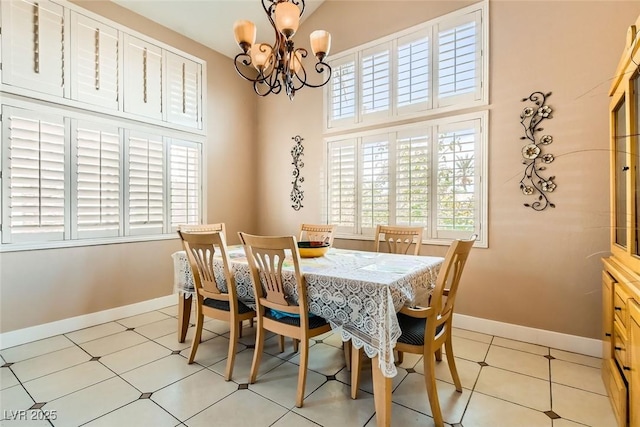 dining room featuring an inviting chandelier, a towering ceiling, and baseboards