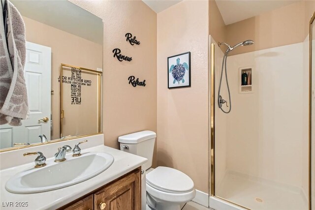 full bathroom featuring toilet, a stall shower, and vanity