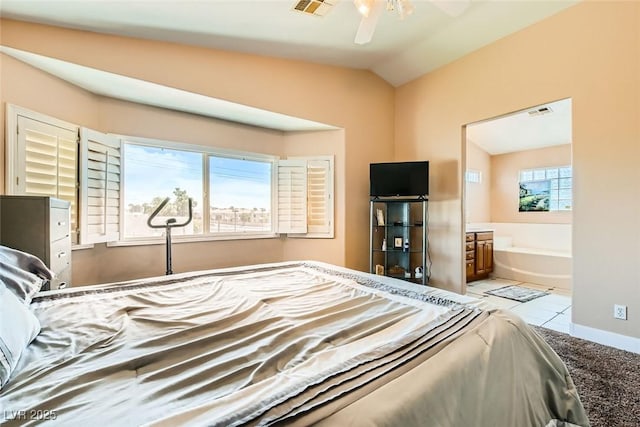 bedroom featuring tile patterned floors, vaulted ceiling, ensuite bath, baseboards, and visible vents