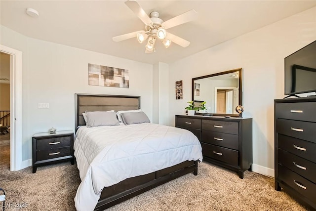 bedroom with baseboards, a ceiling fan, and light carpet