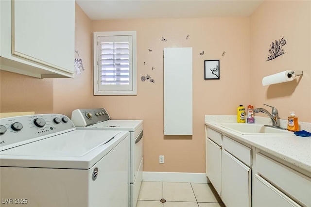 laundry room with washing machine and dryer, a sink, light tile patterned floors, baseboards, and cabinet space