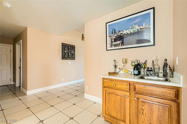bar featuring a sink, a dry bar, and baseboards