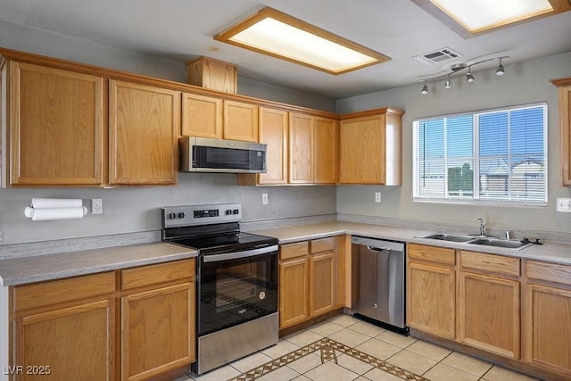 kitchen featuring light countertops, a sink, appliances with stainless steel finishes, light tile patterned floors, and visible vents