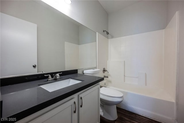 full bath featuring toilet, wood finished floors, vanity, and bathing tub / shower combination