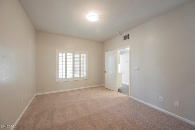 spare room with baseboards, visible vents, and carpet flooring