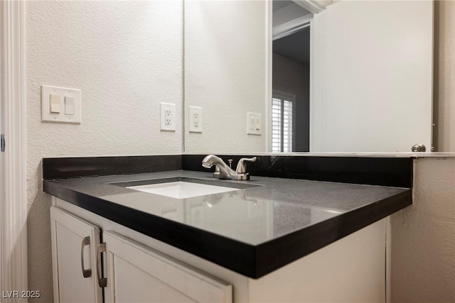 bathroom with vanity and a textured wall