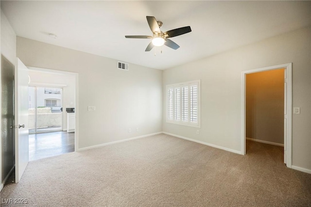 unfurnished room with plenty of natural light, baseboards, carpet, and a ceiling fan