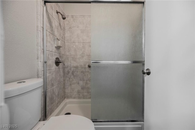 full bath featuring toilet and a stall shower